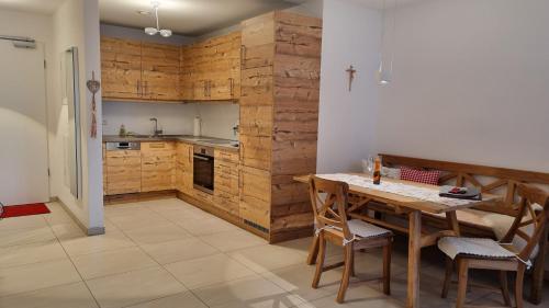 a kitchen with a table and a wooden wall at Landlust am See in Schwangau