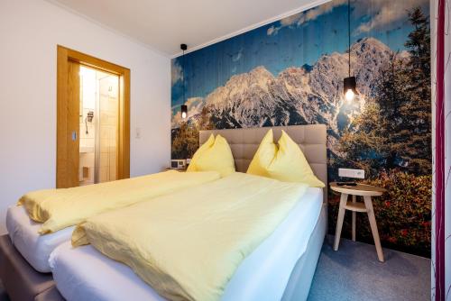 a bedroom with a large bed with a painting on the wall at Energiepension Schwaiger in Leogang
