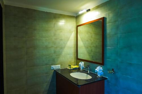 a bathroom with a sink and a mirror at Jagira Ananta Elite , Sasan Gir in Chitrod