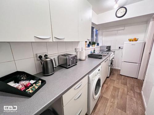 a kitchen with white cabinets and a counter top at Supersized 5bed house/Birmingham/Monthly discounts in Birmingham