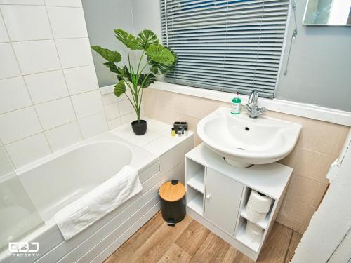 a bathroom with a sink and a bath tub and a toilet at Supersized 5bed house/Birmingham/Monthly discounts in Birmingham