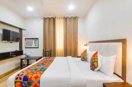 a bedroom with a large bed and a television at FabHotel Shyam Inn in Kānpur