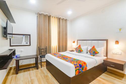 a bedroom with a bed and a desk and a television at FabHotel Shyam Inn in Kānpur