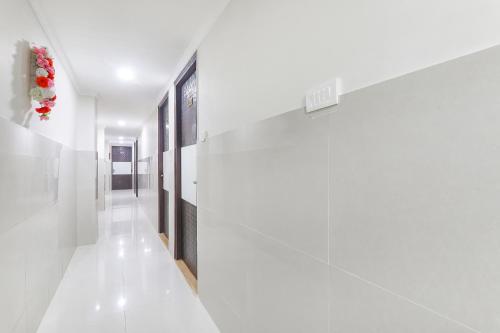 a hallway with white walls and white floors at FabHotel Shyam Inn in Kānpur