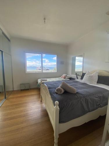 a bedroom with a large bed with two windows at The Ultimate Beach House in Kingston Beach