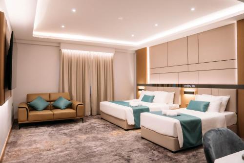 Habitación de hotel con 2 camas y sofá en Crystal Inn en Batu Pahat