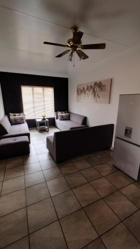 sala de estar con 2 sofás y ventilador de techo en Mukumbura Swartwater, 