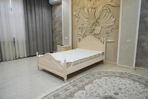 a bedroom with a bed with a flower on the wall at Казахстан 13 in Tashkent