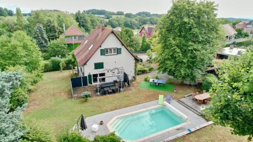 eine Luftansicht eines Hauses mit Pool in der Unterkunft MORTZI villa 4 étoiles avec piscine in Mortzwiller