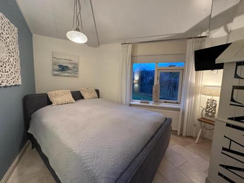 Un dormitorio con una cama grande y una ventana en Seestern 336, en Julianadorp