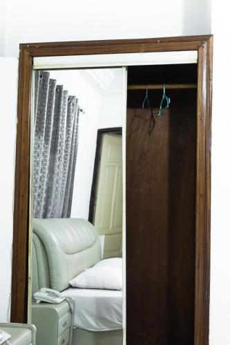 a mirrored door leading into a bedroom with a mirror at Hill View Hotel West Airport in Accra
