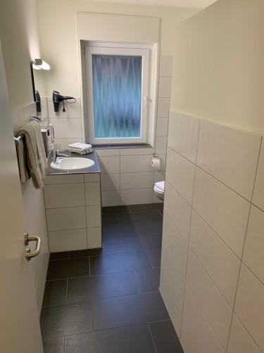 baño con lavabo y ventana en Metzgerei Stiebeling - Stolberger Hof, 
