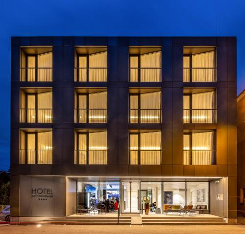 an exterior view of a hotel at night at Hotel Katharinenhof COMFORT in Dornbirn