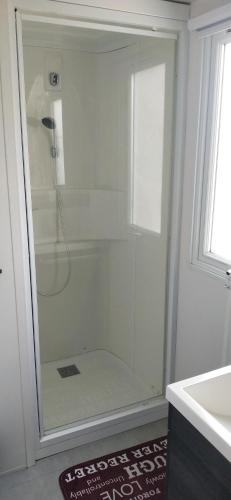 a shower stall in a bathroom with a sink at Camping Siblu les Charmettes in Les Mathes