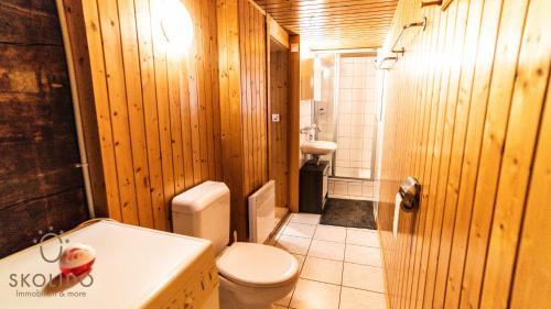 een houten badkamer met een toilet en een wastafel bij Heimeliges Walliserhaus in Fiesch