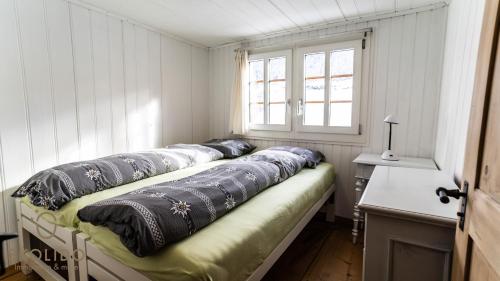 een bed met kussens in een kamer met een raam bij Heimeliges Walliserhaus in Fiesch