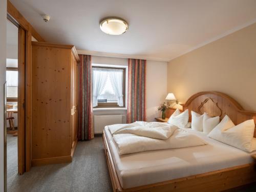 a bedroom with a large white bed and a window at Hotel Andrea in Mayrhofen