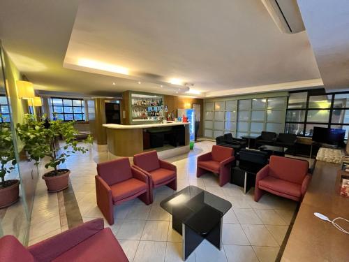 a lobby of a hotel with chairs and a bar at Hotel La Goletta in Binasco