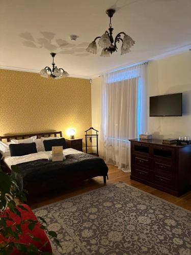 a bedroom with a bed and a flat screen tv at Embrace Hotel & Apartments in Pärnu