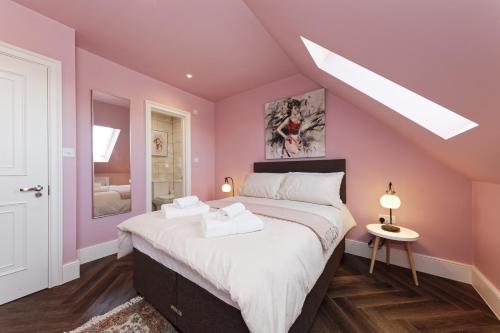 a bedroom with pink walls and a large bed at The Eagles in Ramsgate