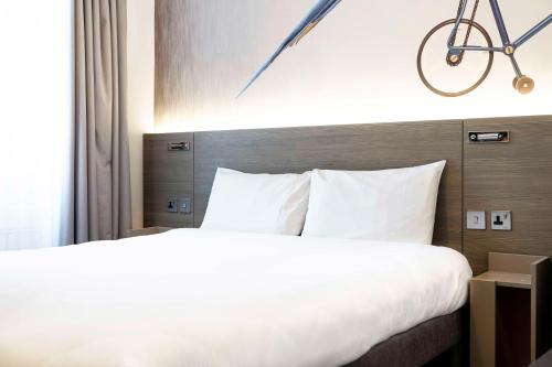 a bed in a hotel room with a bike on the wall at Heeton Concept Hotel - Kensington London in London