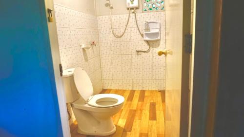 a small bathroom with a toilet and a shower at Tanachporn Homestay ธนัชพร โฮมสเตย์ เมืองจันทบุรี in Chanthaburi