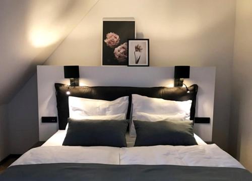 a bedroom with a large bed with white sheets and pillows at Hotel Maribor & Garden Rooms in Maribor