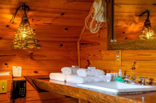 a bathroom with a sink and towels on a counter at Pousada Rancho Das Framboesas in Visconde De Maua