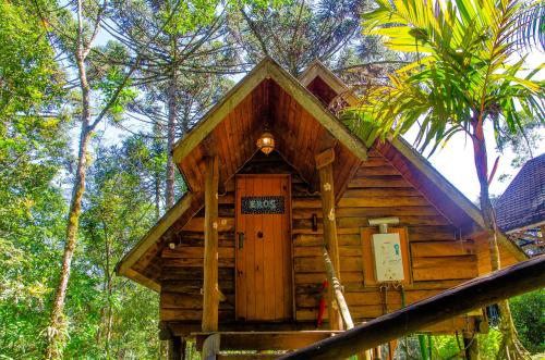 a small wooden cabin in the middle of trees at Pousada Rancho Das Framboesas in Visconde De Maua