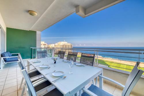 a dining room with a table and a view of the ocean at Stunning Seafront Lux Apt Fort Cambridge wt POOL in Sliema