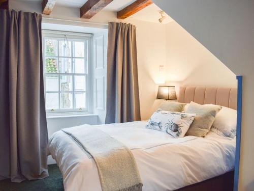 a bedroom with a large bed with a window at Fisher Gallery in Pittenweem