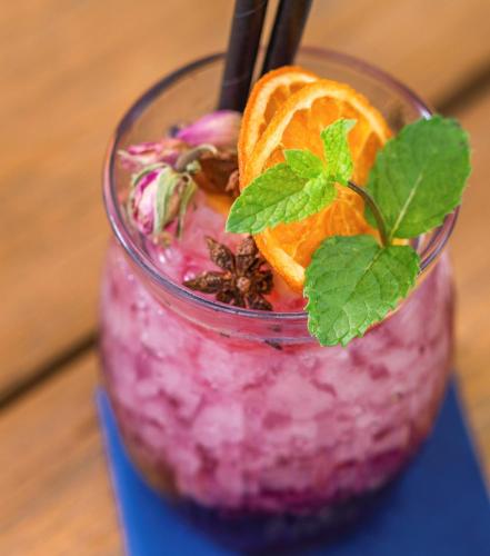 a glass jar filled with a pink drink with an orange slice at Beach Bay Hvar Hotel in Hvar