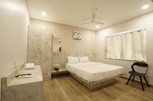 um quarto com uma cama e uma cadeira em HOTEL TRP BLISS em Nizāmābād