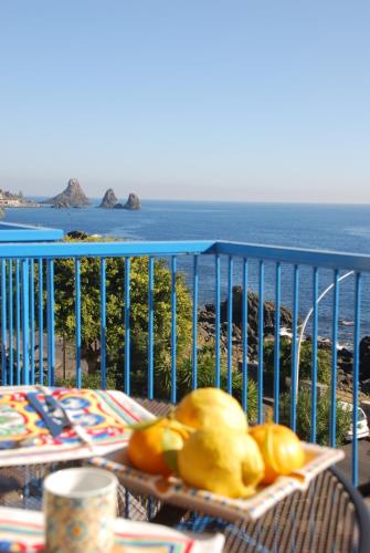una mesa con vistas al océano en un balcón en Casa Il Delfino, en Aci Castello