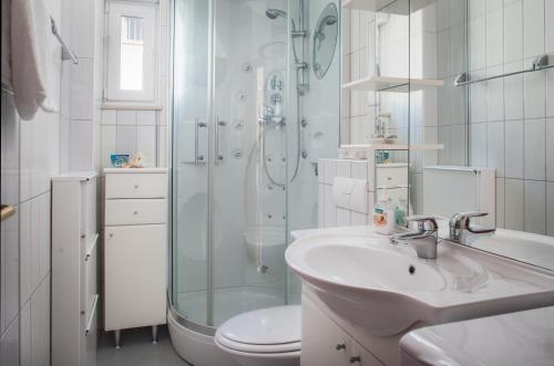 a bathroom with a shower and a sink and a toilet at Apartmani Vito i Cvita in Makarska