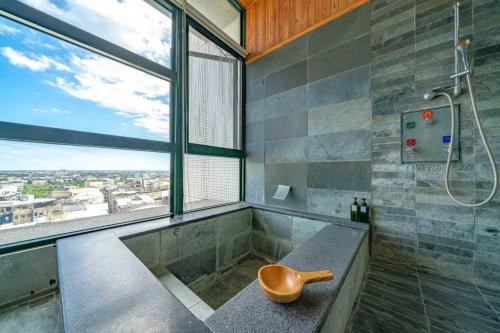 a bathroom with a shower with a bench and a sink at 暖暖窩溫泉湯旅 in Yü-shih-ts'un