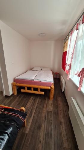a bedroom with a bed in the corner of a room at Chalupa u rybára s Wellness a detským ihriskom in Liptovský Trnovec