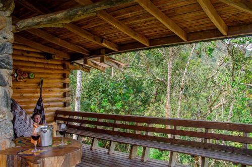a girl sitting on the porch of a cabin at Pousada Rancho Das Framboesas in Visconde De Maua