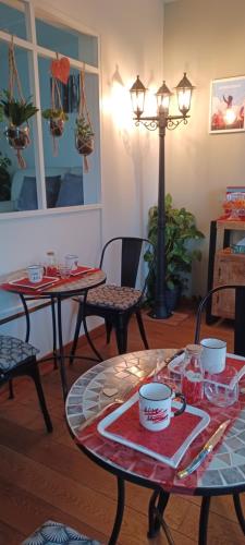 twee tafels en stoelen in een woonkamer bij La Carte Postale in Oye-Plage