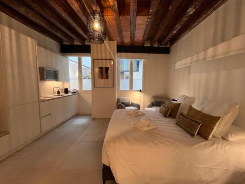 a bedroom with a large white bed with a wooden ceiling at Homely Málaga Mariblanca 17, Vegafuente Apartments in Málaga