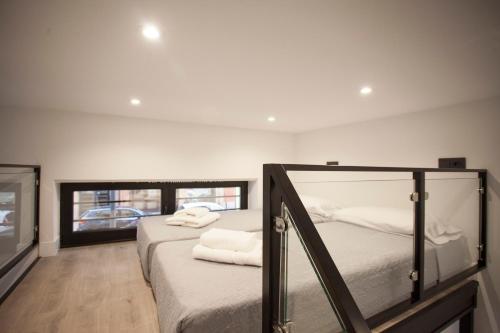 a bedroom with two beds with white sheets at CC Atocha Apartments in Madrid