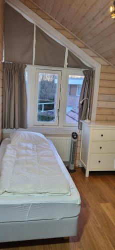 1 dormitorio con 1 cama blanca y 2 ventanas en The Black House - Luxurious Holiday Villa Zeewolde en Zeewolde