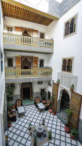 a large room with a patio with chairs and a table at Riad Green House in Fès