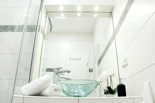ein Badezimmer mit einem Glaswaschbecken und einem Spiegel in der Unterkunft SECRET HIDEAWAYS cozySTUDIO 1 superior Apartment mit WiFi l 450m bis Uni l Zoo in Duisburg
