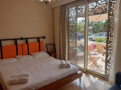 a bedroom with a bed and a sliding glass door at Mangroovy - 1BR Glamorous Gouna view condo in Hurghada