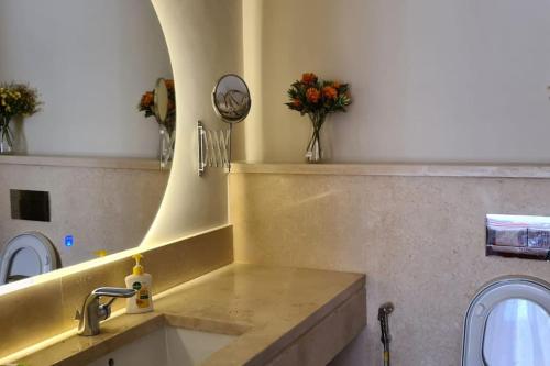a bathroom with a sink and a mirror and flowers at Mangroovy - 1BR Glamorous Gouna view condo in Hurghada