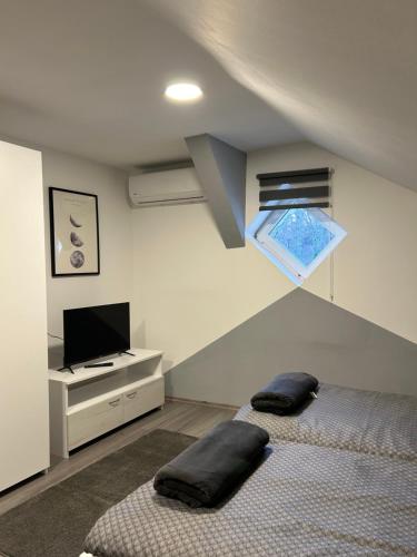 a bedroom with two beds and a flat screen tv at Sobe “Stari Grad-Samobor” in Samobor