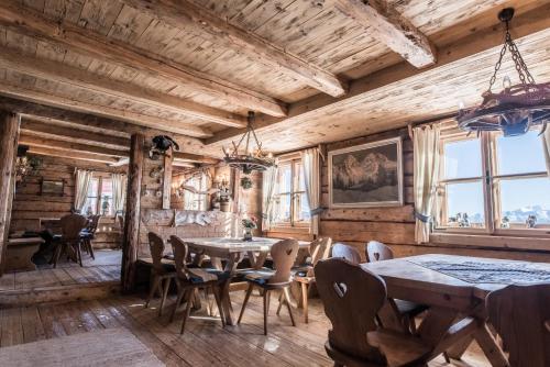 a dining room with wooden walls and tables and chairs at Berggasthaus & Lodge Resterhöhe in Mittersill