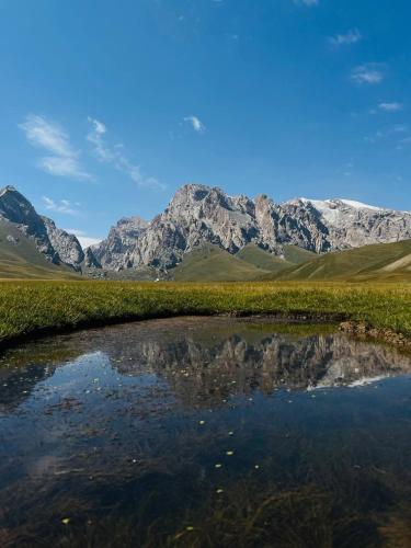 a reflection of a mountain in a body of water at Bars Yurt Camp in Ak-Say