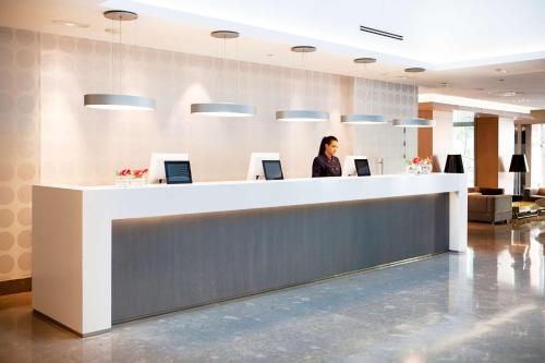 a woman standing at a reception desk in an office at NH Madrid Principe de Vergara in Madrid